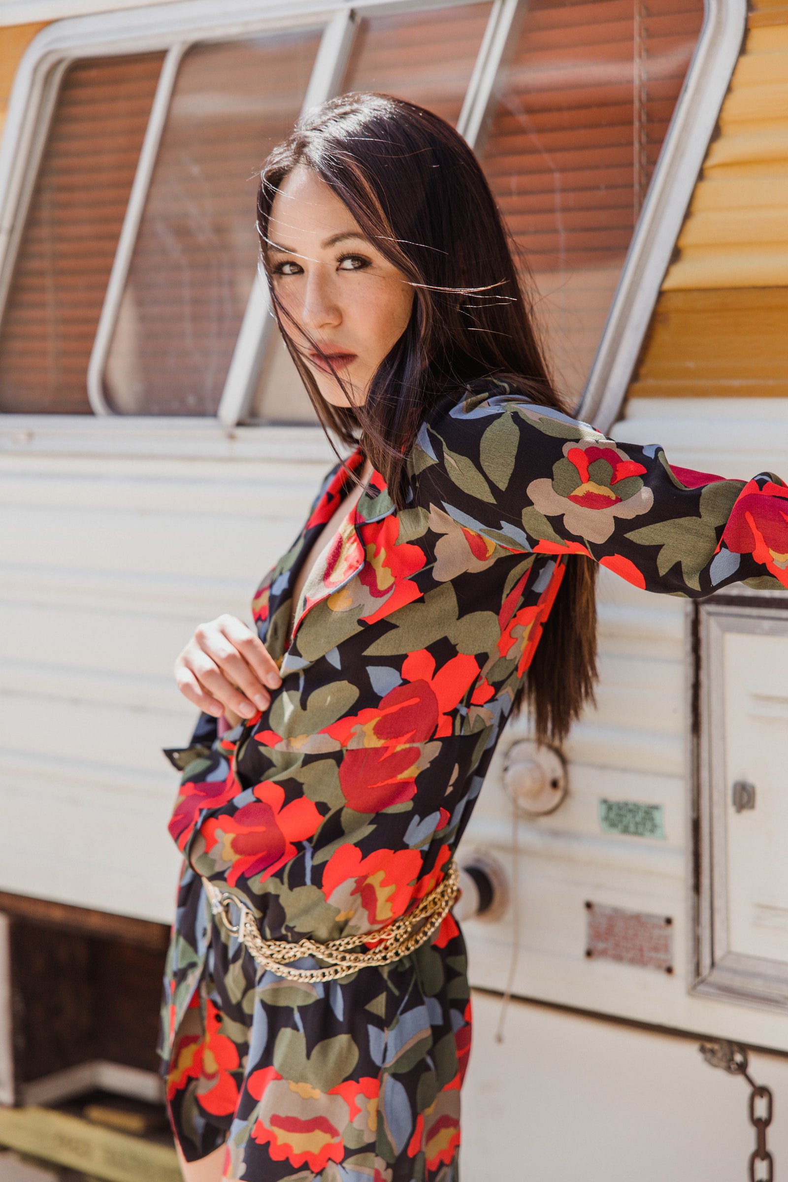 Akane Millan wearing a floral look beside a vintage trailer