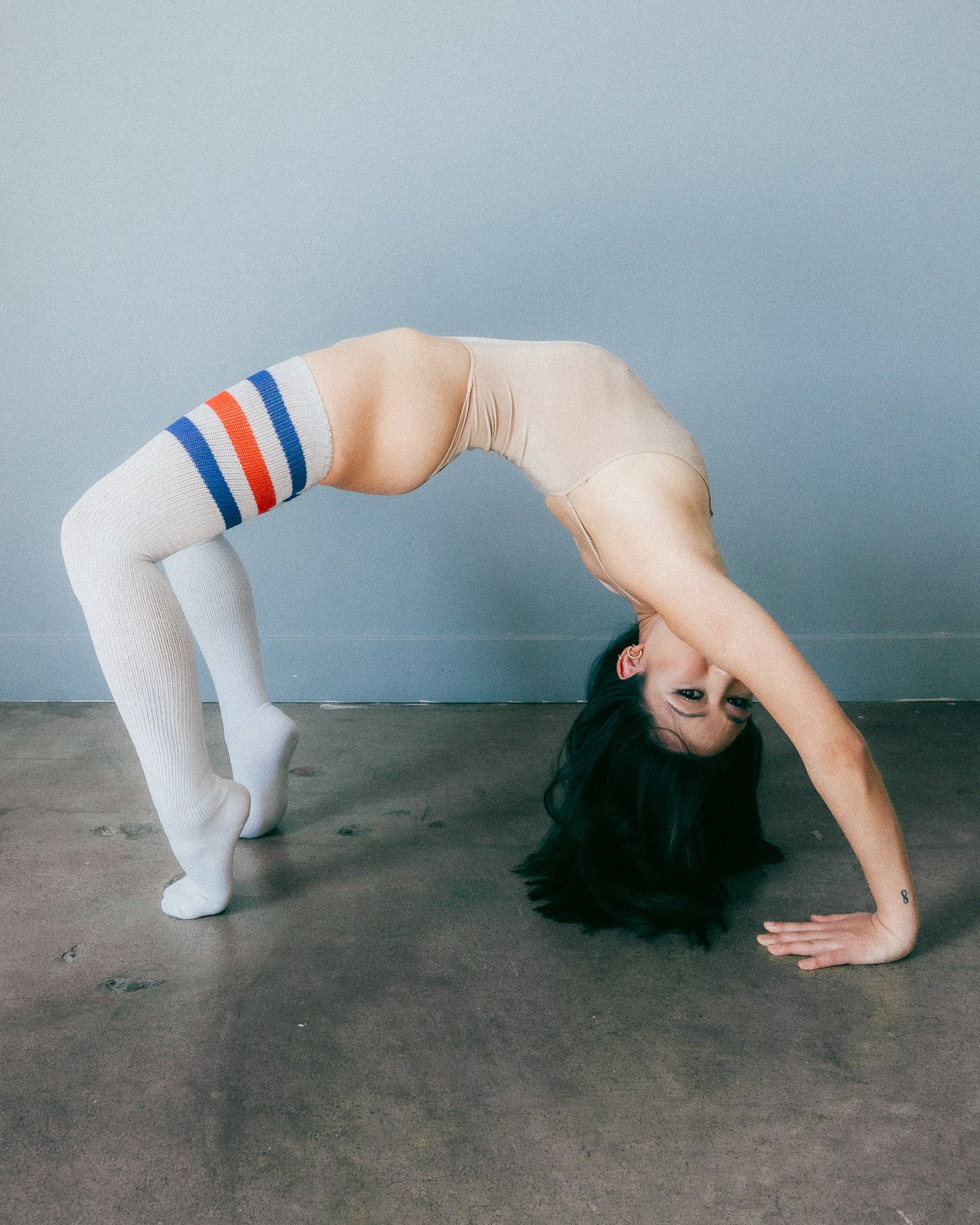 Akane Millan holding a studio wheel pose
